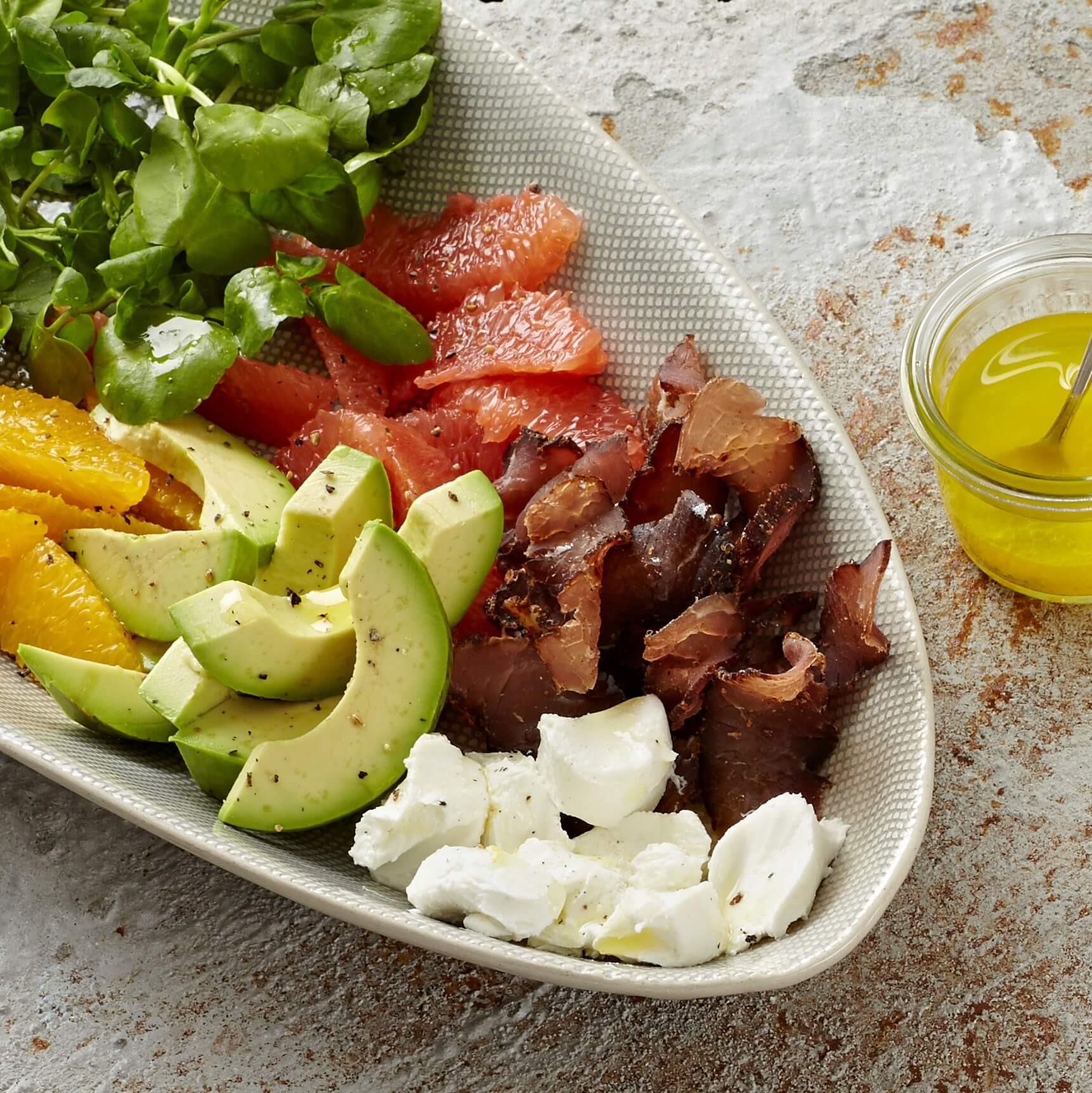 Bowl filled with avocado, citrus and biltong